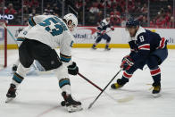 Washington Capitals left wing Alex Ovechkin (8) and San Jose Sharks defenseman Nicolas Meloche (53) fight for the puck during the first period of an NHL hockey game, Wednesday, Jan. 26, 2022, in Washington. (AP Photo/Evan Vucci)