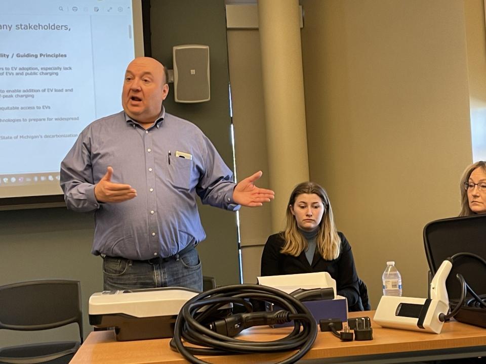 Electric vehicle driver Bill LaVoy of Monroe shows EV chargers at Saturday's EV Forum. Next to him are (from left): Karissa Lomas and Joei Lemanski, both from Friendly Ford.