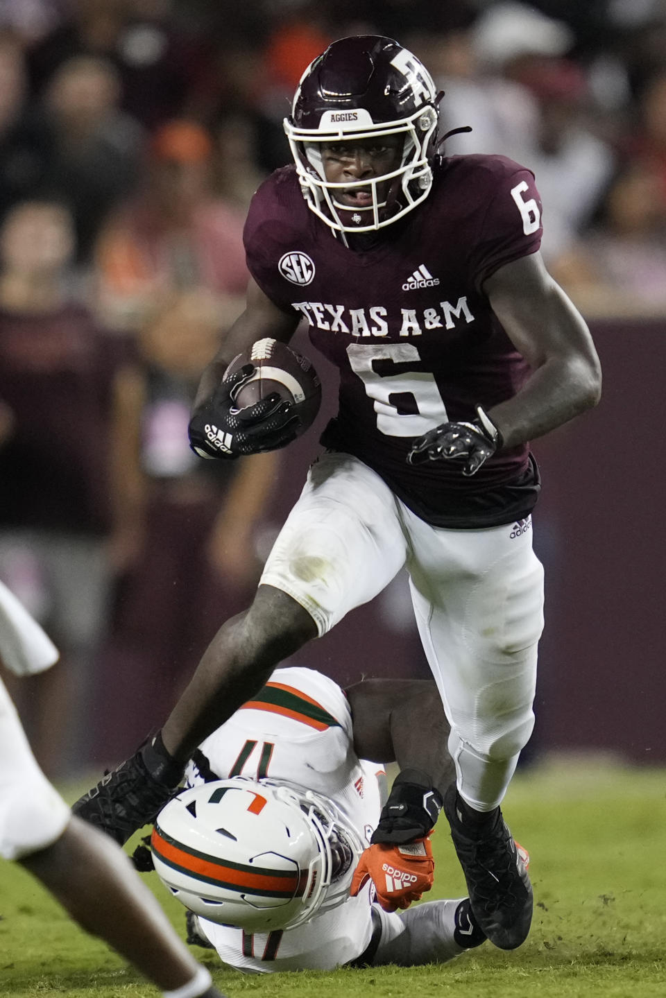 Texas A&M running back Devon Achane (6) sheds a tackle attempt by Miami linebacker Waynmon Steed Jr. (17) to pick up a first down during the second quarter of an NCAA college football game Saturday, Sept. 17, 2022, in College Station, Texas. (AP Photo/Sam Craft)