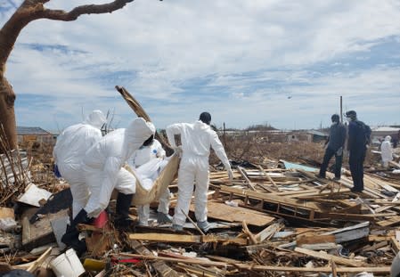 Members of the Bahamian Defense Force remove bodies from the destroyed Abaco shantytown called Pigeon Peas