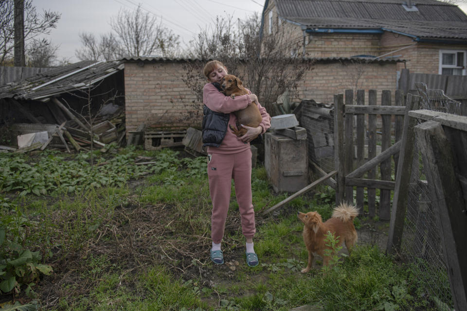 Iryna Stetcenko pets a dog in a yard of her house in the village of Demydiv, about 40 kilometers (24 miles) north of Kyiv, Ukraine, Tuesday, Nov. 2, 2022. Environmental damage caused by Ukraine’s war is mounting in the 8-month-old conflict, and experts warn of long-term health consequences for the population. The World Wildlife Fund in Ukraine says more than 6 million people have limited or no access to clean water. “We don’t have another option. We don’t have money to buy bottles,” Iryna Stetcenko told The Associated Press. (AP Photo/Andrew Kravchenko)