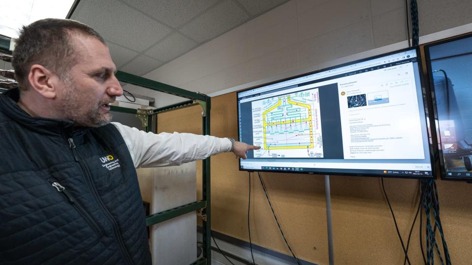 Pawel Olszewski points to a diagram of flameless impingement oven, which mixes air and flammable gas in such a way that it creates heat without visible flame.