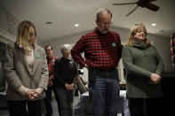 Abigail Bessler, left,daughter of Democratic presidential candidate Sen. Amy Klobuchar, D-Minn., left, joins a pre-dinner prayer while attending a campaign gathering Tuesday, Jan. 21, 2020, in Stanton, Iowa. (AP Photo/Marcio Jose Sanchez)