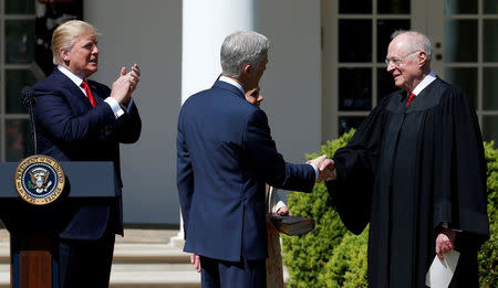 FILE PHOTO: Judge Neil Gorsuch shakes hands with Justice Anthony Kennedy after he was sworn as an Associate Supreme Court as U.S. President Donald J. Trump watches in the Rose Garden of the White House in Washington, U.S. on April 10, 2017. REUTERS/Joshua Roberts/File Photo