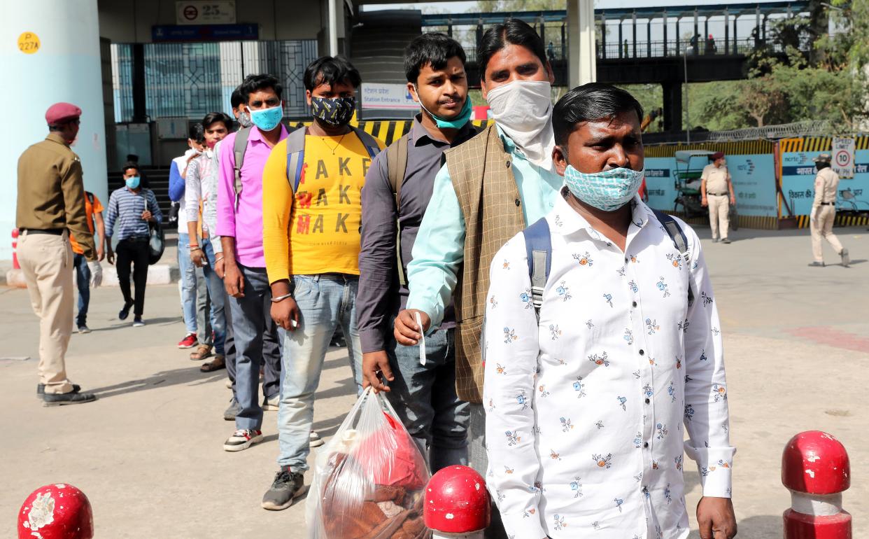 <p>People wait to undergo a Covid-19 swab test at the Anand Vihar bus station in Delhi, 8 April 2021</p> (EPA)