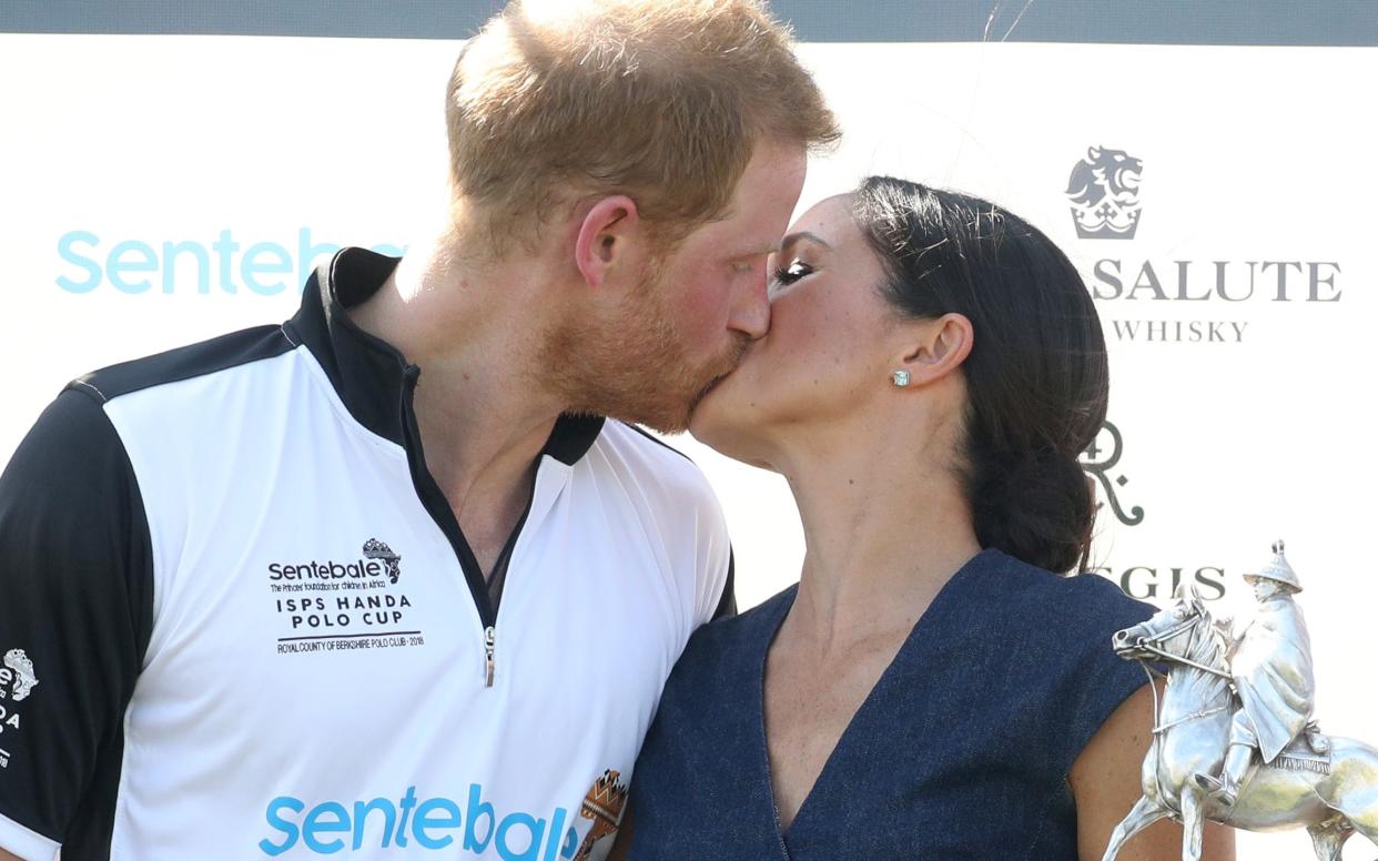 Meghan Duchess of Sussex and Prince Harry Duke of Sussex kiss after posing with the trophy after the Sentebale Polo 2018 held at the Royal County of Berkshire Polo Club on July 26, 2018 in Windsor, England - 2018 Getty Images