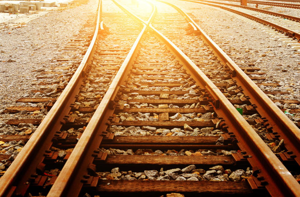 Rail road tracks with the sun shining brightly.