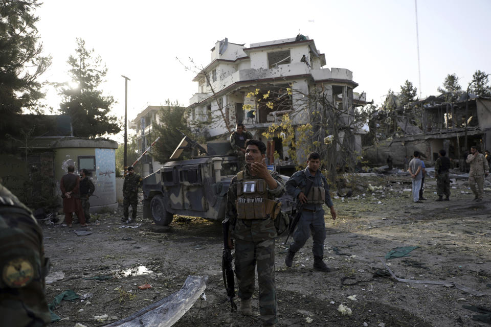 Afghan security personnel inspect around a damaged building following an attack in Kabul, Afghanistan, Wednesday, Aug. 4, 2021. A powerful explosion rocked an upscale neighborhood of Afghanistan's capital Tuesday in an attack that apparently targeted the country's acting defense minister. (AP Photo/Rahmat Gul)