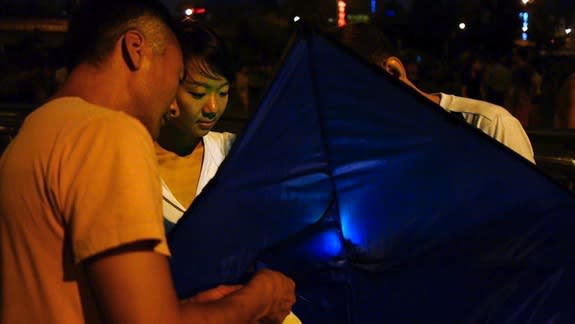 Beijing residents prepare to fly a kite for sensing air pollution.