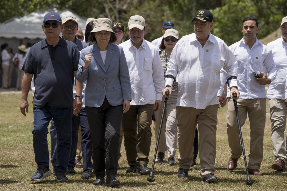 Taiwan's President Tsai Ing-wen, left, and Guatemala's President Alejandro Giammattei, walk to speak with reporters during their visit of the Mayan site Tikal, in Peten, Guatemala, Saturday, April 1, 2023. Tsai is in Guatemala for an official three-day visit. (AP Photo/Moises Castillo)