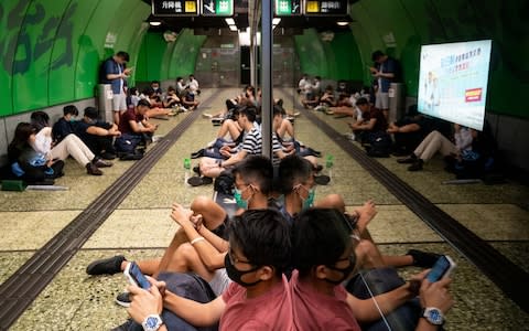 Protesters sit on the ground of the platform at the Fortress Hill MTR Station - Credit: Anthony Kwan/Getty images