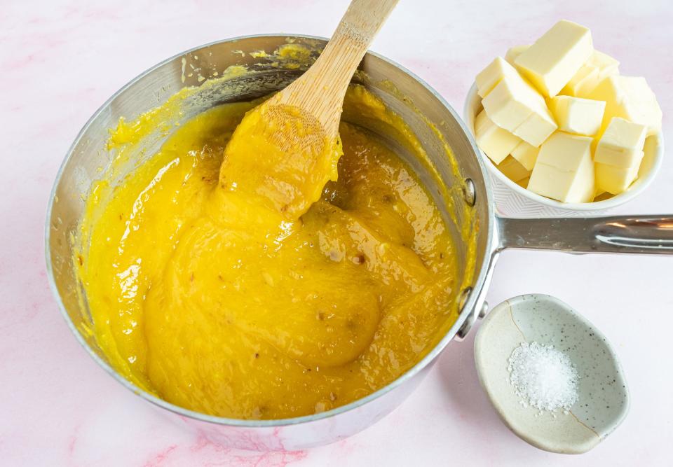 adding citrus zest to eggs with wooden spoon with butter next to bowl