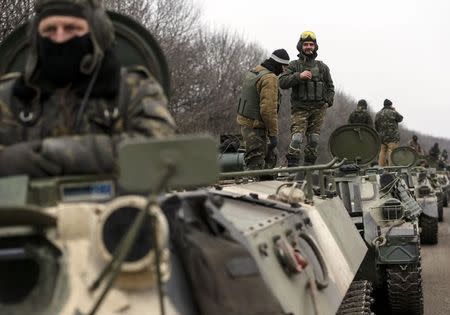 Members of the Ukrainian armed forces and armoured personnel carriers are seen preparing to move as they pull back from Debaltseve region, near Artemivsk February 26, 2015. REUTERS/Gleb Garanich