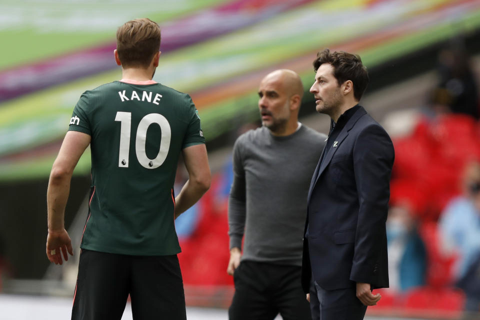 <p>Tottenham's interim head coach Ryan Mason talks to Tottenham's Harry Kane, with Manchester City's head coach Pep Guardiola in the background, during the English League Cup final soccer match between Manchester City and Tottenham Hotspur at Wembley stadium in London, Sunday, April 25, 2021. (AP Photo/Alastair Grant)</p>
