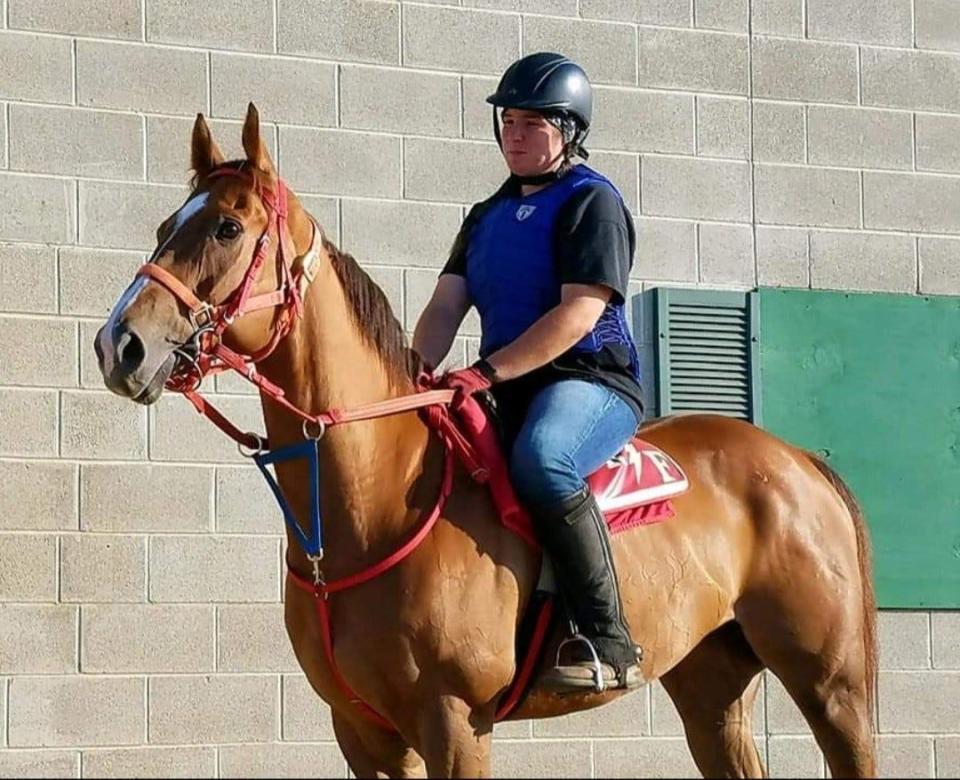 Cassie Dempsey aboard a horse at JACK Thistledown Racino, where she works as an assistant starter