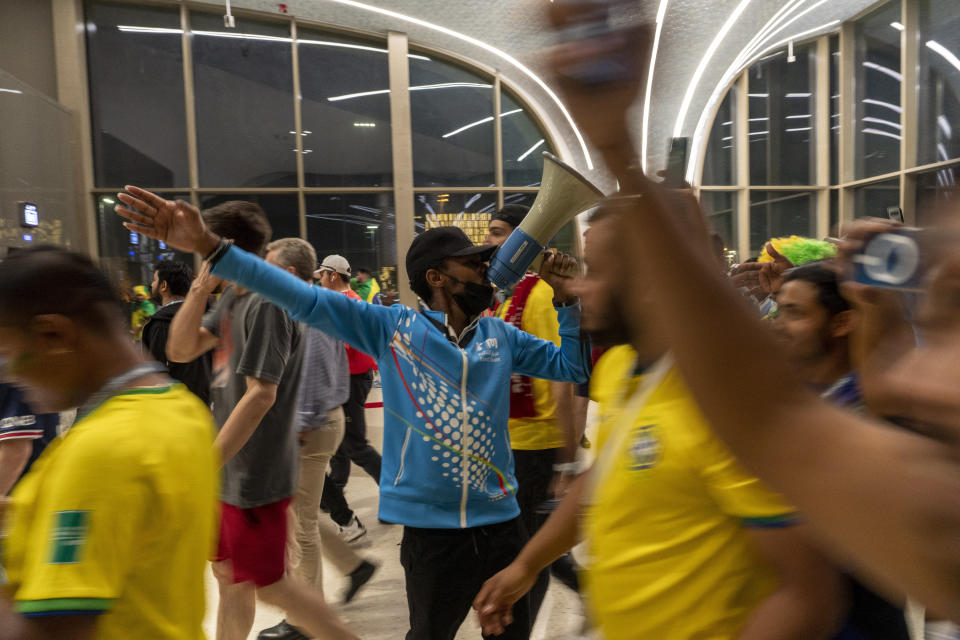 A street marshal gives indications to fans at a subway station prior to the World Cup group G soccer match between Brazil and Serbia, at the Lusail Stadium in Lusail, Qatar, Thursday, Nov. 24, 2022.The World Cup 2010 in South Africa had Shakira. The 1998 World Cup in France had Ricky Martin. In Qatar, the tune that nests itself in the head is the incessant chanting of street marshals, better knows as Last Mile Marshals. Seated all over Doha on high chairs more commonly used by lifeguards at swimming pools, these migrant workers have become a staple of the Middle East's first World Cup. (AP Photo/Moises Castillo)