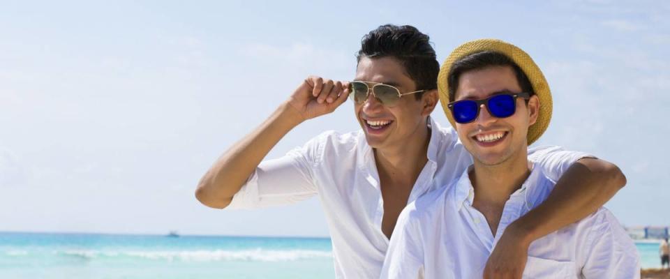 Gay couple drinking a coconut in the Caribbean