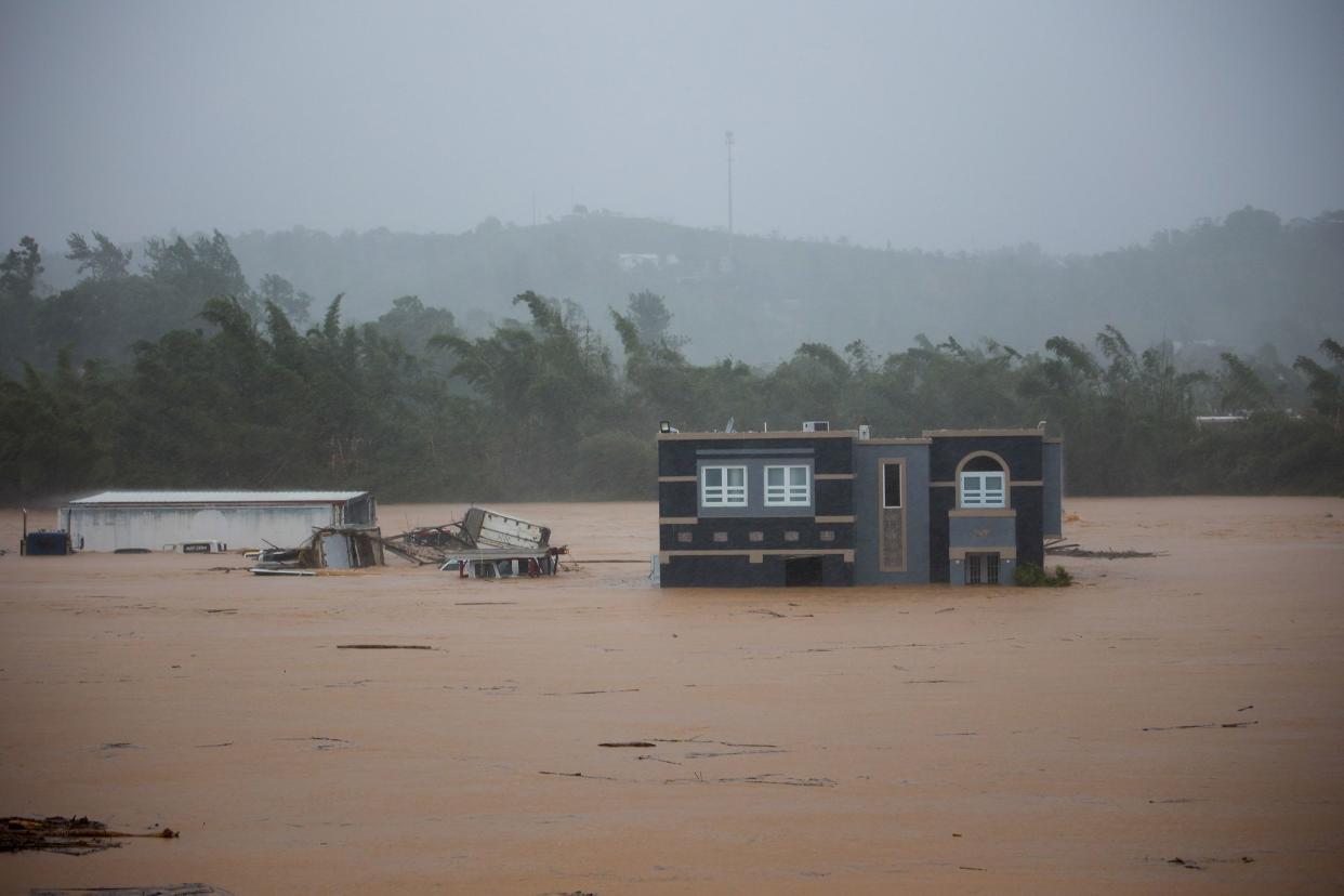 A home is submerged in floodwaters caused by Hurricane Fiona in Cayey, Puerto Rico on Sunday, Sept. 18, 2022.  According to authorities three people were inside the home and were reported to have been rescued.