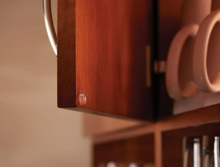 Close-up of an open wooden cabinet with a cabinet bumper applied to the corner