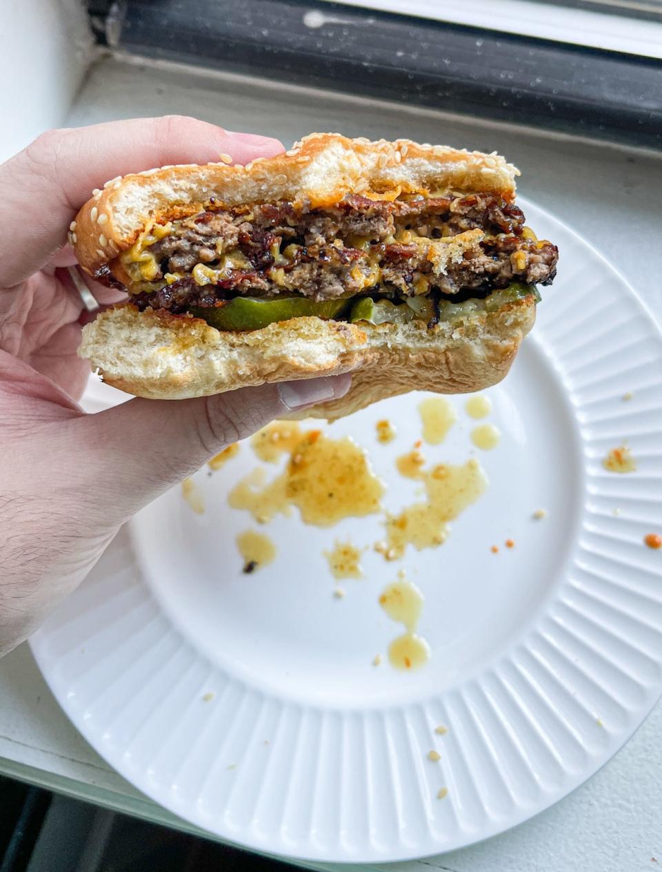 burger juices below the burger on a white plate