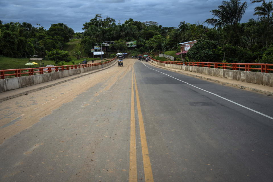 A moto-taxi driver crosses a bridge, part of a federal highway project that extends over the Nanay River, in Iquitos, Peru, Tuesday, May 28, 2024. The project, which spans 188 kilometers (117 miles), is intended to connect Iquitos, the main city in Peru's Amazon, with the El Estrecho district on the Colombian border. (AP Photo/Rodrigo Abd)