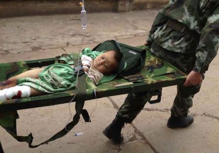 An injured child is carried by paramilitary policemen on a stretcher after an earthquake hit Longtoushan township of Ludian county, Yunnan province August 3, 2014. REUTERS/Stringer