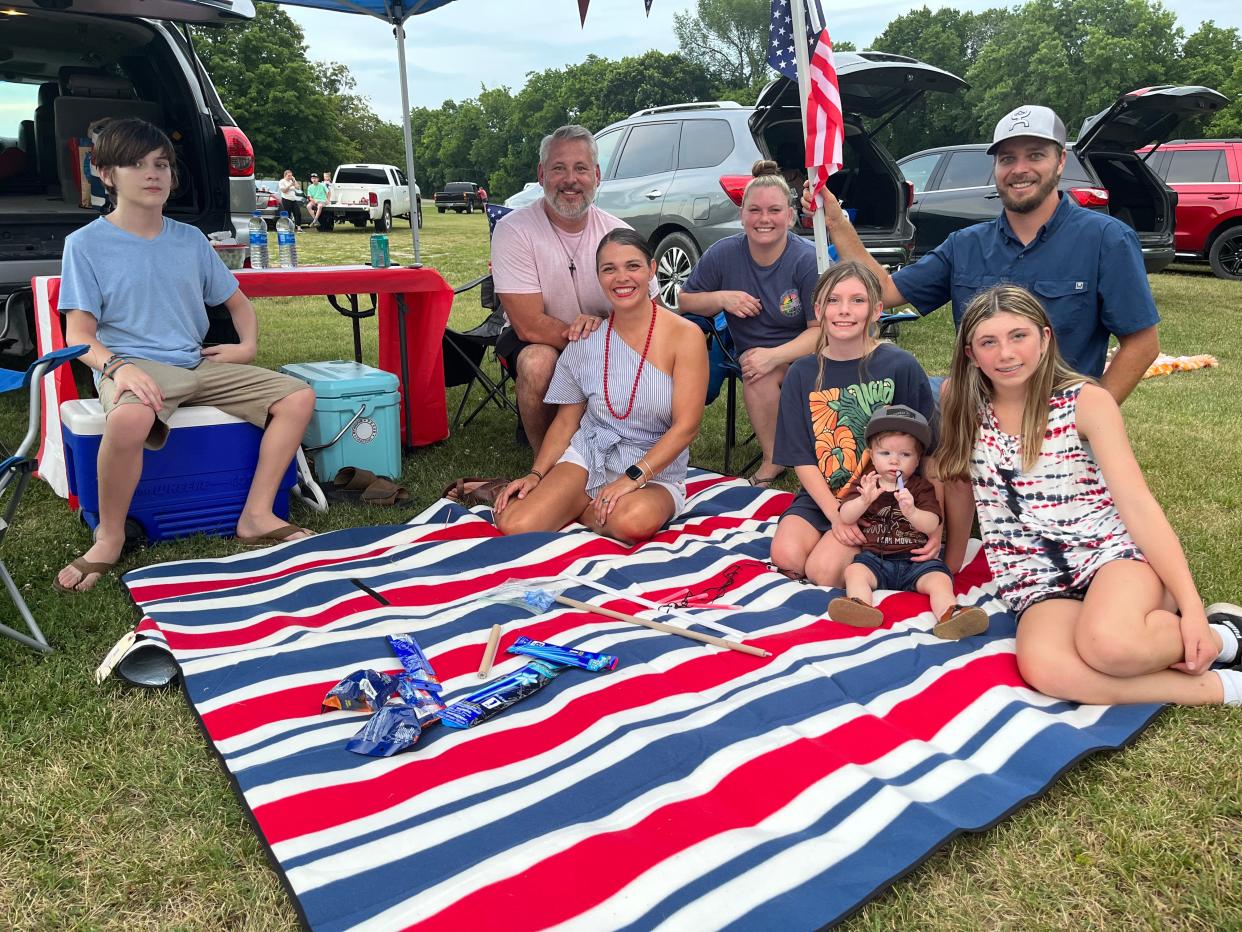 Shawn and Deanna O'Brien (middle) hang out with family and friends on a blanket awaiting the fireworks show at Maury County Park in Columbia, Tenn. on July 4, 2023. They are joined by (left) David Cole, Christin Garmann, Talylynn Robinson, 11, Beckett Garmann, 1, Austin Garmann and Trinity Robinson, 13.