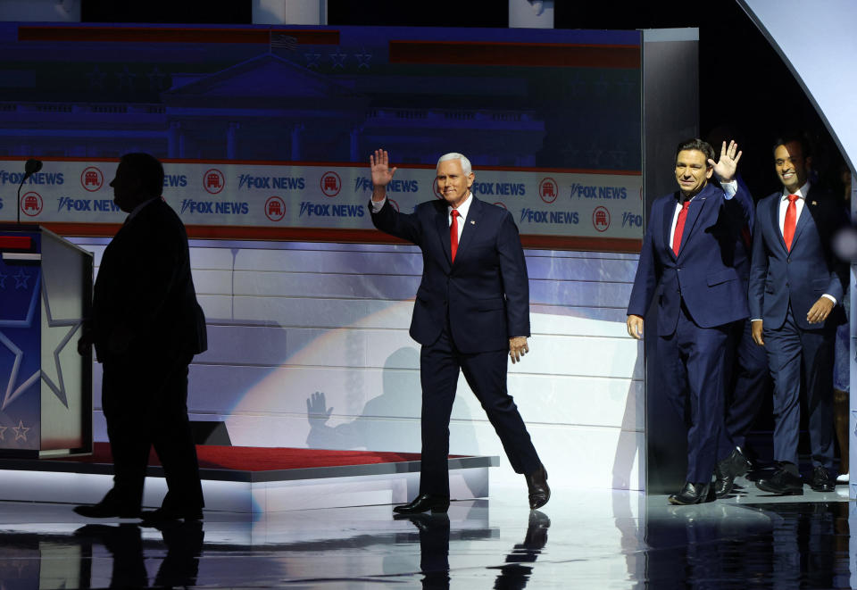 Former Vice President Mike Pence, Florida Gov. Ron DeSantis and businessman Vivek Ramaswamy arrive onstage at the start of the debate.