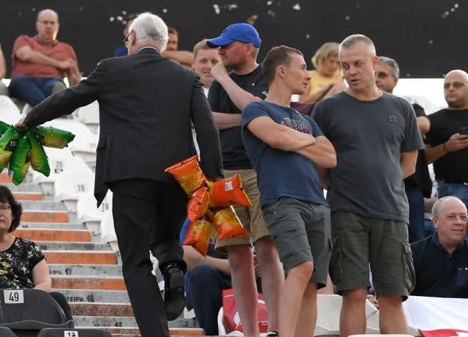 Chelsea chairman Bruce Buck hands out packets of crisps to travelling Blues fans