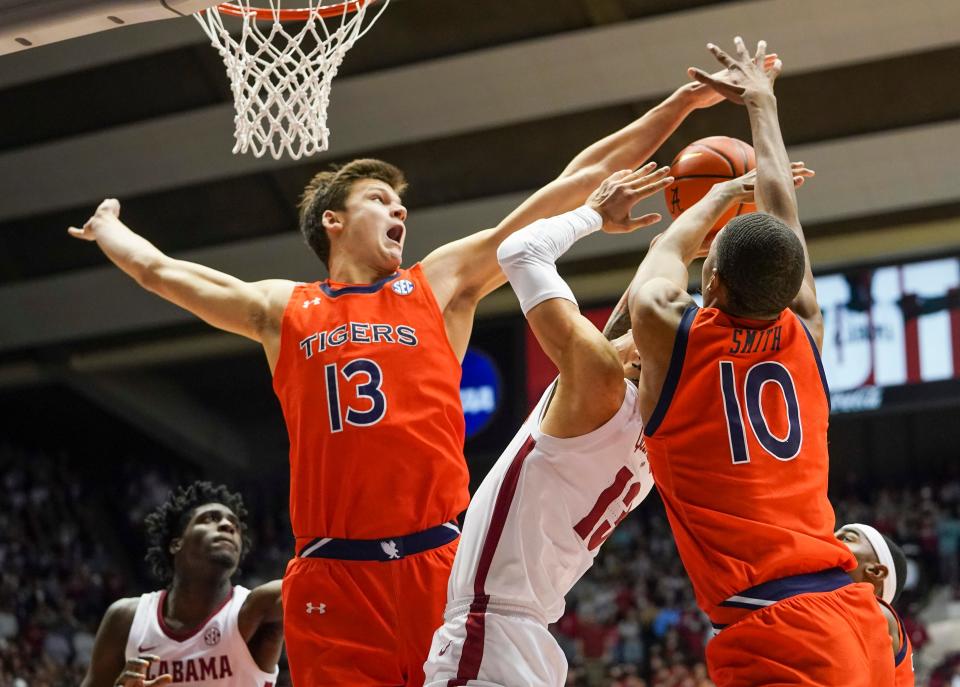 Jan 11, 2022; Tuscaloosa, Alabama, USA; Alabama Crimson Tide guard Jahvon Quinerly (13) shoots against Auburn Tigers forward Walker Kessler (13) and forward Jabari Smith (10) during the second half at Coleman Coliseum. Mandatory Credit: Marvin Gentry-USA TODAY Sports