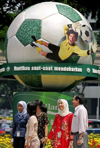 Malaysians walk past an advertisment for the World Cup in downtown Kuala Lumpur in 2006. Gambling on football is illegal in Malaysia. Most other types of gambling also are illegal outside of the country's sole casino resort in the Genting Highlands near the capital Kuala Lumpur