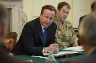 British Prime Minister David Cameron speaks as he chairs the Government's emergency meeting at 10 Downing Street in central London to address the developing flood situation, Wednesday Feb. 12, 2014. Troops have been deployed to help in the flood effort as much of the country is bracing itself for more extreme weather over the coming days. Major General Patrick Sanders at right. (AP Photo/Neil Hall, PA) UNITED KINGDOM OUT - NO SALES - NO ARCHIVES