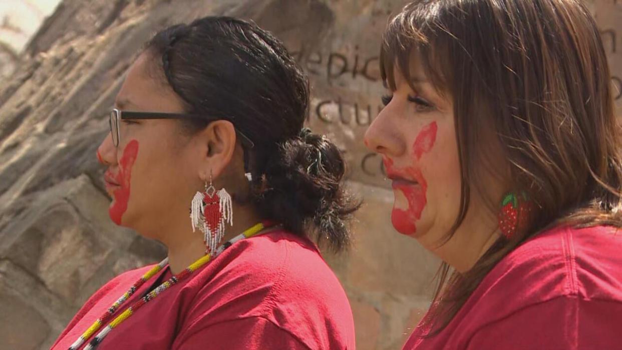 Dozens attended an event at The Forks Sunday to mark Red Dress Day, a nationally recognized day observed annually on May 5 to raise awareness for missing and murdered Indigenous women, girls and two-spirit people  (CBC - image credit)