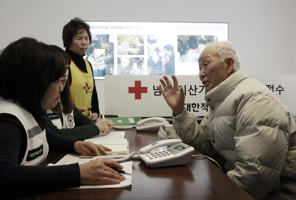 South Korean Lee Kyun-myoung, 93, right, talks with Red Cross members as he fills out application forms to reunite with his family members living in North Korea, at the Korea Red Cross headquarters in Seoul, South Korea, Thursday, Feb. 6, 2014. The rival Koreas agreed Wednesday to hold their first reunions of Korean War-divided families in more than three years later this month, another small step forward in easing tensions that comes despite North Korea's anger over upcoming U.S.-South Korean military drills. (AP Photo/Ahn Young-joon)