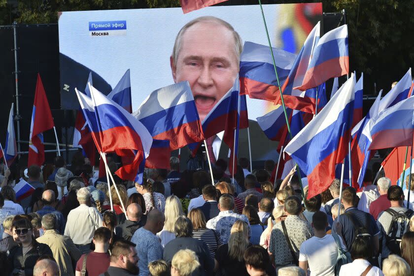 People watch as Russian President Vladimir Putin delivers his speech after a ceremony to sign the treaties for four regions of Ukraine to join Russia in the Moscow's Kremlin, during a meeting in Sevastopol, Crimea, Friday, Sept. 30, 2022. The signing of the treaties making the four regions part of Russia follows the completion of the Kremlin-orchestrated "referendums." (AP Photo)