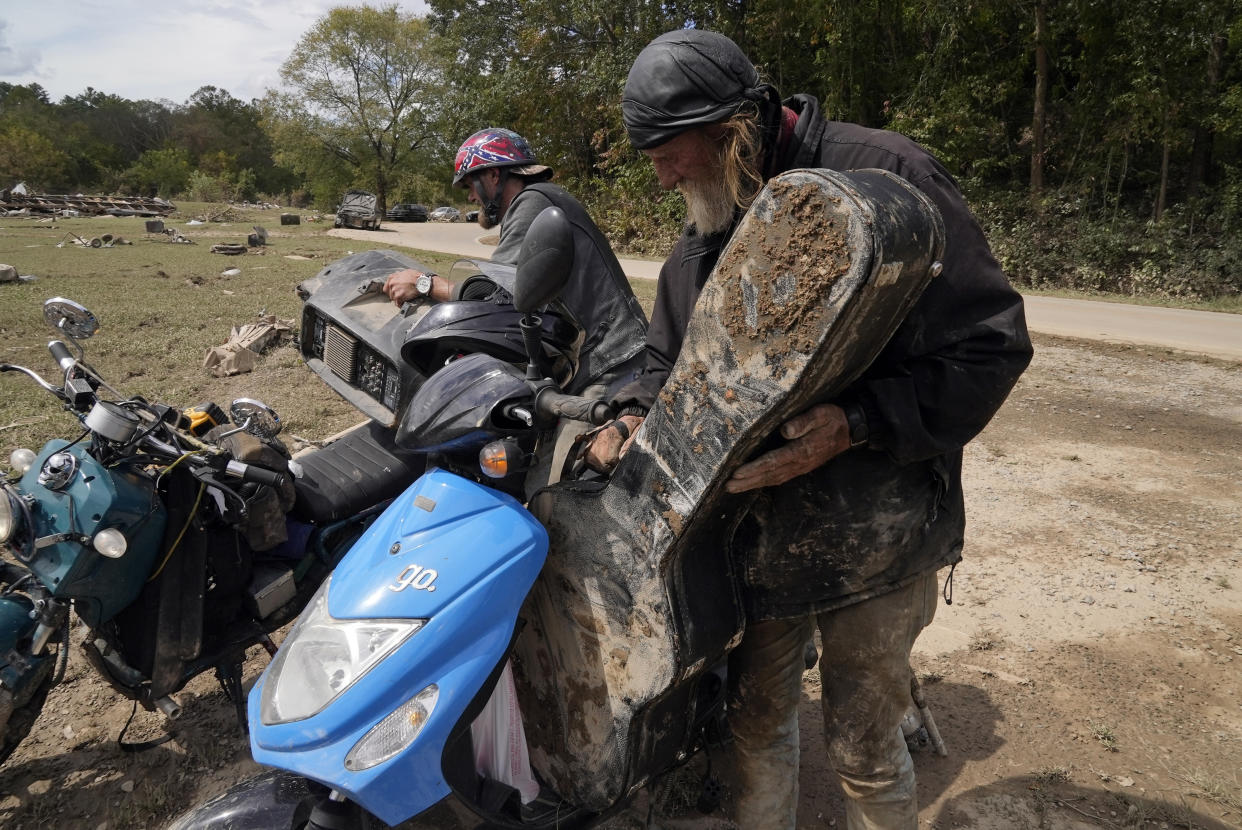 Friends Robert Smith and David Mayben salvage items from the home of a family member who passed away in flooding, Tuesday, Oct. 1, 2024 in Hendersonville, N.C., in the aftermath of Hurricane Helene. (AP Photo/Brittany Peterson)