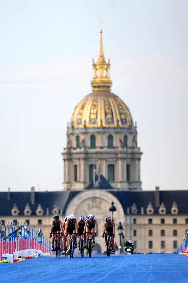 British athlete Beth Potter (second from left) competing in the women's individual triathlon together with a group of other athletes on their bicycles. 