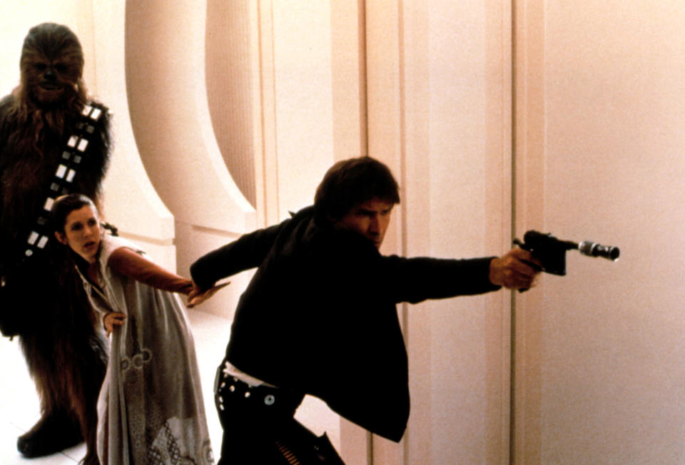 Han points a gun to protect Leia and Chewbacca