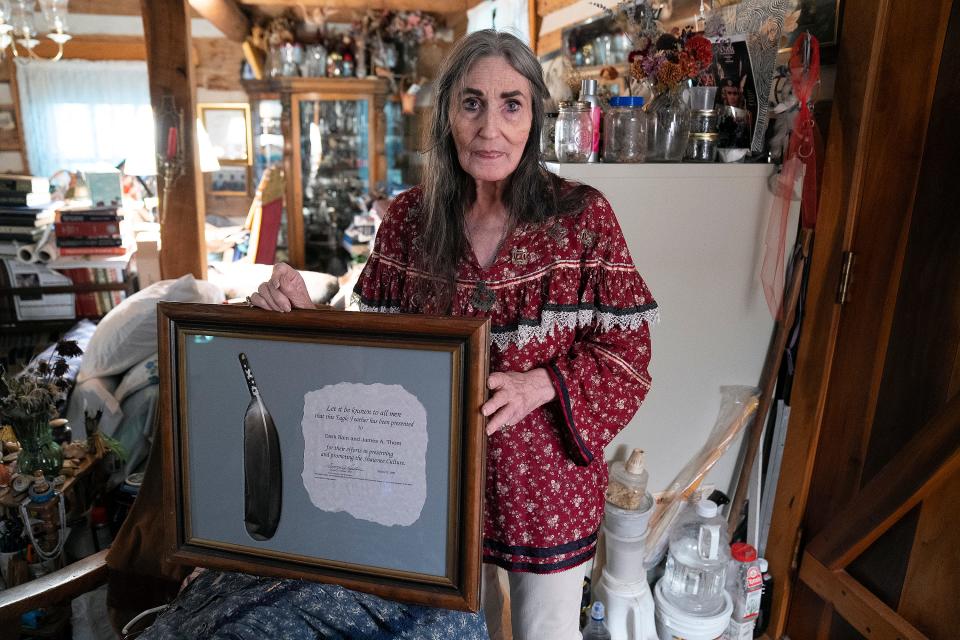 Dark Rain Thom displays an eagle feather given to her in recognition of the work that she and her late husband, James A. Thom, have done in support of Shawnee Culture, created by the Eastern Shawnee Tribe of Oklahoma.