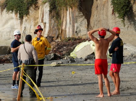 Emergency responders attend to a cliff collapse at a beach in Encinitas, California