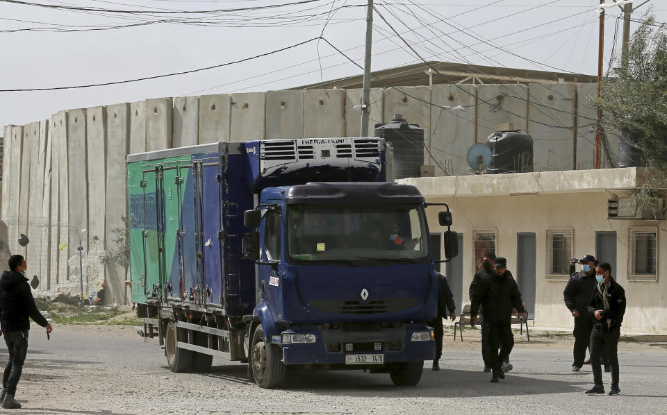 Hamas police officers guard a truck containing a shipment of Russian Sputnik V coronavirus vaccines at the Kerem Shalom border crossing, in Rafah, Gaza Strip, Wednesday, Feb. 17, 2021. The Palestinian Authority said Wednesday that it dispatched the first shipment of coronavirus vaccines to the Hamas-ruled Gaza Strip, two days after accusing Israel of preventing it from sending the doses amid objections from some Israeli lawmakers. (AP Photo/Adel Hana)