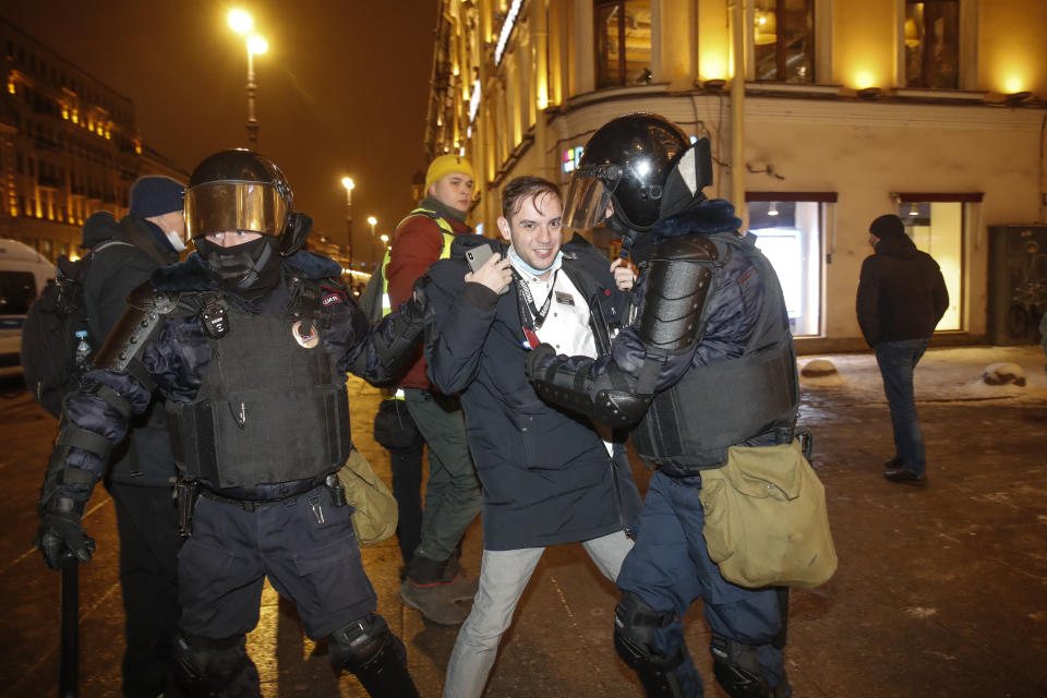 Police officers detain a Navalny supporter during a protest in St. Petersburg, Russia, Tuesday, Feb. 2, 2021. A Moscow court has ordered Russian opposition leader Alexei Navalny to prison for more than 2 1/2 years on charges that he violated the terms of his probation while he was recuperating in Germany from nerve-agent poisoning. Navalny, who is the most prominent critic of President Vladimir Putin, had earlier denounced the proceedings as a vain attempt by the Kremlin to scare millions of Russians into submission. (AP Photo/Dmitri Lovetsky)