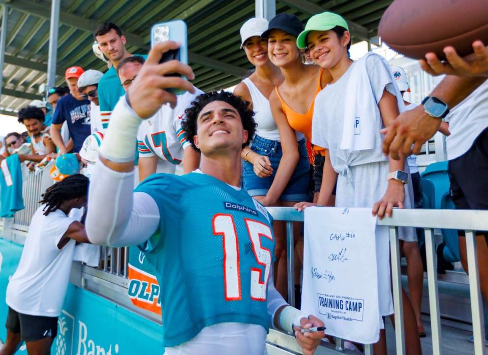 Miami Dolphins linebacker Jaelan Phillips (15) takes a selfie with a fan after NFL football training camp at Baptist Health Training Complex in Hard Rock Stadium on Sunday, July 30, 2023 in Miami Gardens, Florida.
