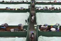 Rain covers over courts at the Wimbledon Tennis Championships in London, July 2, 2015. REUTERS/Toby Melville