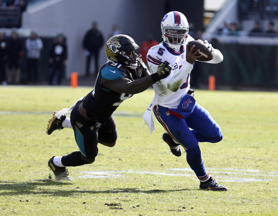 Jacksonville Jaguars defensive end Yannick Ngakoue (91) tries to stop Buffalo Bills quarterback Tyrod Taylor as he scrambles from the pocket in the first half of an NFL wild-card playoff football game, Sunday, Jan. 7, 2018, in Jacksonville, Fla. (AP Photo/Stephen B. Morton)