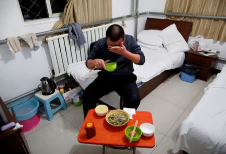 Yuan Yunping wipes sweat from his face as he eats dinner, which his son cooked for him, in his room at the accommodation where some patients and their family members stay while seeking medical treatment in Beijing, China, January 13, 2016. REUTERS/Kim Kyung-Hoon