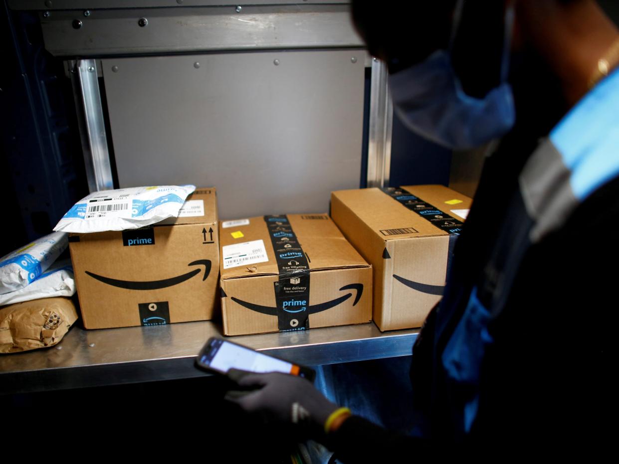 FILE PHOTO: An Amazon worker delivers packages amid the coronavirus disease (COVID-19) outbreak in Denver, Colorado, U.S., April 22, 2020. Picture taken April 22, 2020. REUTERS/Kevin Mohatt/File Photo