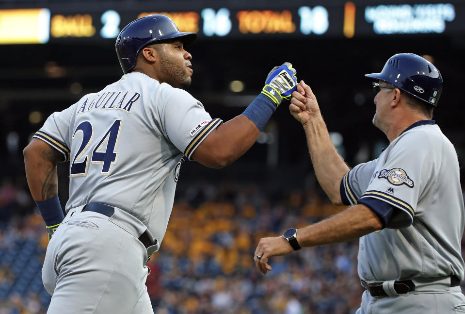 Milwaukee Brewers' Jesus Aguilar (24) rounds third base to greetings from third base coach Ed Sedar after hitting a solo home run off Pittsburgh Pirates starting pitcher Chris Archer during the third inning of a baseball game in Pittsburgh, Friday, May 31, 2019. (AP Photo/Gene J. Puskar)