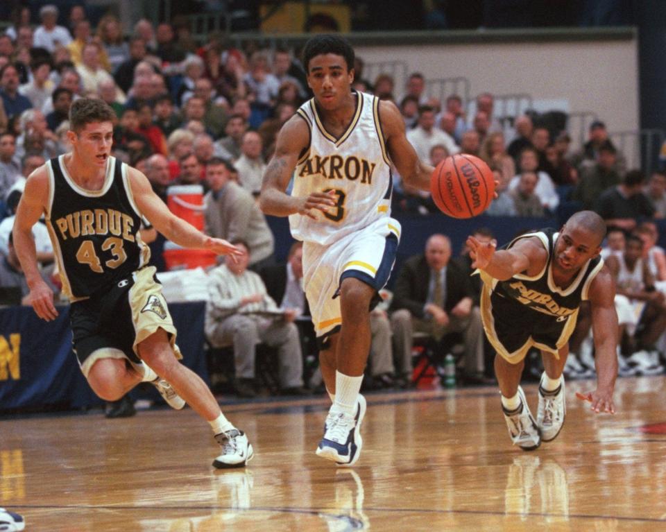 Akron guard Andre Sims pushes the ball up the court at Rhodes Arena in front of Purdue's Maynard Lewis (right) and Carson Cunningham (left), Dec. 27, 2000.