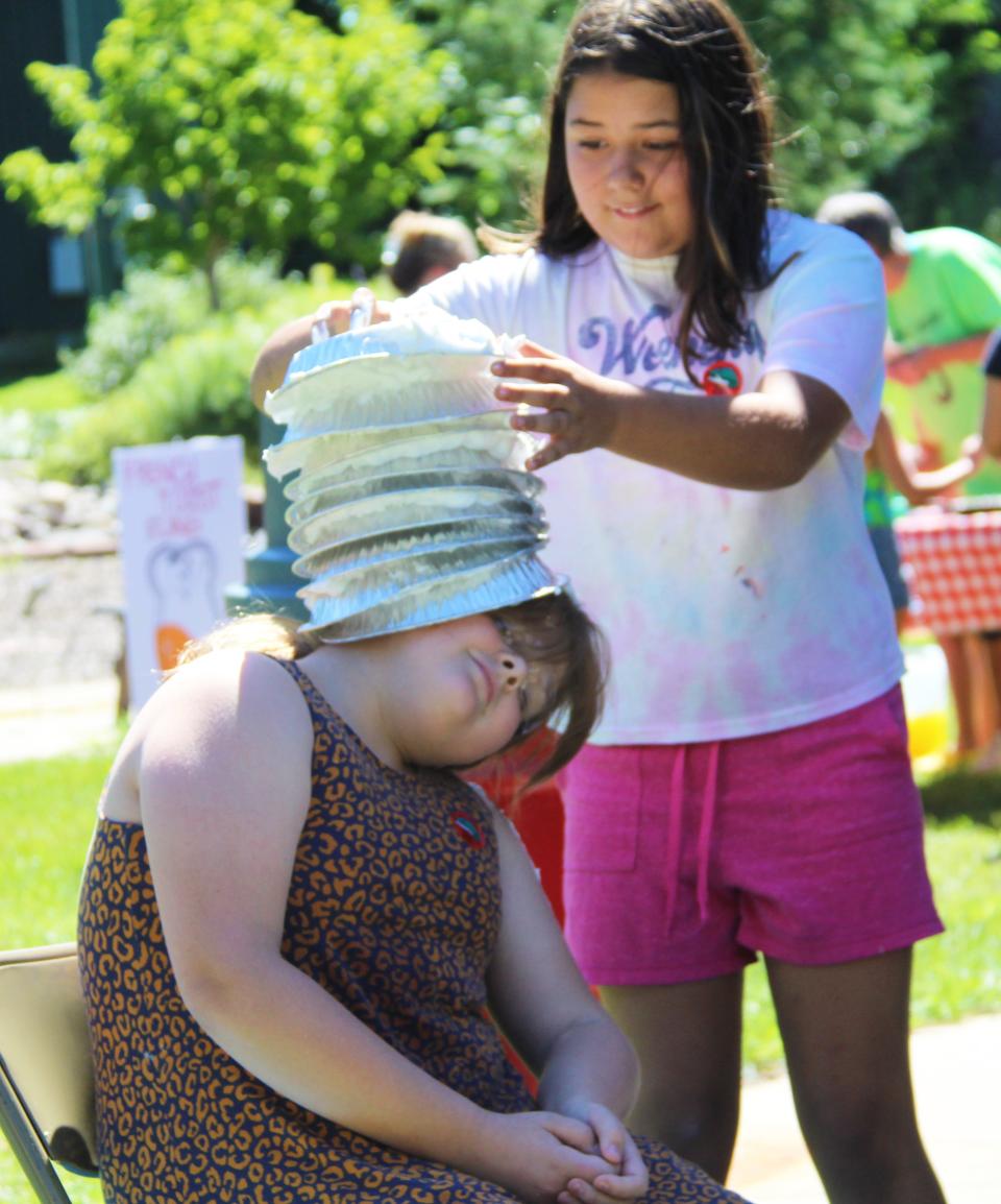 As Ava Smith stacked "mud pie hats" on her team mate, Aszpen Curtis kept it all balanced. It was one event at the Colon Library summer reading slime challenge.